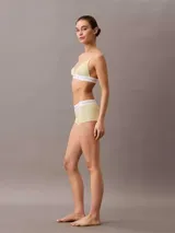 Corpiño triangular de Calvin Klein confeccionado en tejido acanalado de algodón y modal. Presenta copas suaves, tirantes ajustables y una banda elástica inferior con el logo de la marca en contraste.