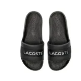 Ojotas de goma negras con banda ancha sobre el empeine con el logo de Lacoste en blanco.