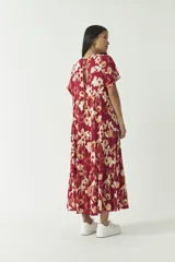 Vestido largo color borgoña con estampado floral en tonos beige. Corte holgado con mangas cortas y falda escalonada.