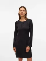 Vestido midi de color negro con textura acanalada ondulada, cuello redondo y mangas largas. Presenta un diseño ajustado al cuerpo con una caída fluida.