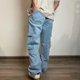 Pantalón jean cargo gris con efecto lavado, corte recto y bolsillos laterales.