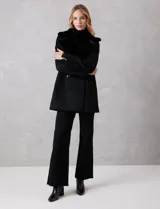 Tapado de lana Michael Kors con doble abotonadura y cuello de solapa ancha revestido en piel sintética. Presenta cierre frontal con seis botones grabados, bolsillos laterales de ojal y silueta de corte recto a la altura del muslo.