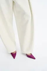 Zapato de tacón destalonado color fucsia con efecto charol, punta fina, tacón fino alto y tiras finas ajustables alrededor del tobillo con hebilla metálica.