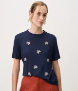 Remera de viscosa azul marino con cuello redondo, mangas cortas y bordados florales repartidos en el frente.