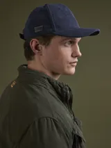 Campera de algodón color azul marino con cuello alto, cierre frontal con cremallera y botones a presión, cuatro bolsillos frontales con solapa y puños con botón.