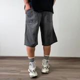 Bermuda de jean corte baggy en color gris oscuro con efecto deslavado, diseño amplio y bolsillos laterales.