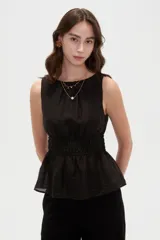 Top de lyocell color negro, sin mangas, con cuello redondo y diseño fruncido con elástico en la cintura que genera un corte peplum.