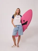 Remera azul marino de algodón con mangas cortas raglán blancas con ribete naranja y estampado ovalado con el logo de Rusty en el pecho.