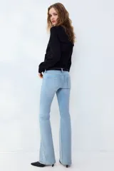 Jean de denim celeste claro con efecto desteñido, tiro bajo, corte ajustado en la parte superior y piernas acampanadas.