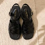 Sandalias de cuero vacuno negro con textura símil cocodrilo, diseño de tiras cruzadas, suela track de goma y hebilla metálica de ajuste en el tobillo.
