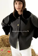 Sobrecamisa de paño de lana color negro, con cuello y puños de cuero napalan con corderito negro. Cuenta con cierre frontal de botones dorados con diseño en relieve.
