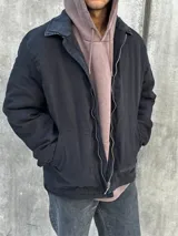 Campera negra con cierre frontal, cuello camisero y bolsillos laterales.