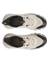 Championes de trail running Under Armour modelo Charged Maven, color beige con detalles en negro y logo celeste. Presentan una parte superior de malla técnica transpirable con refuerzos de poliuretano, entresuela Charged Cushioning para mayor amortiguación y suela de goma con tacos multidireccionales para un agarre óptimo en terrenos irregulares.