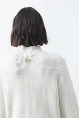 Polera de tejido de punto en color marrón oscuro, con cuello alto y diseño de silueta relajada.