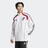 Campera deportiva Adidas de River Plate, color blanco, con detalles en rojo en los hombros y tres franjas negras en las mangas. Presenta cuello alto, cierre frontal y escudo del club bordado.
