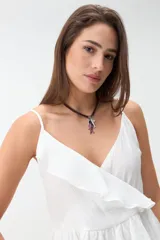 Musculosa blanca de tirantes finos, con escote en V cruzado y detalle de volados en el escote y en el ruedo con diseño de capas.
