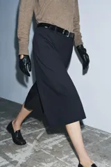 Bermuda larga de tiro medio, color azul marino con finas rayas diplomáticas blancas. Presenta cintura con trabillas, bolsillos laterales ocultos en costura y cierre frontal con cremallera, botón y ganchos metálicos.