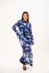 Vestido largo de manga larga con terminación campana, de color azul y violeta con estampado tie-dye, cuello mao con ojal y tajo frontal. Cuenta con flecos en el ruedo y tajo en la pierna.
