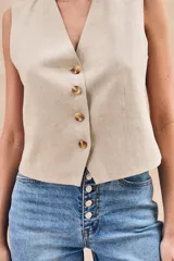 Chaleco negro entallado con escote en V y cierre frontal con cuatro botones.