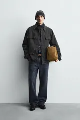 Chaqueta de corte relajado confeccionada en tejido de mezcla de algodón y lyocell con efecto lavado. Presenta cuello solapa, manga larga, cierre frontal con botonadura oculta por solapa y cuatro bolsillos frontales con solapa.