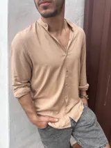 Camisa de lino color beige oscuro, de manga larga con cuello mao y cierre frontal con botones.
