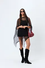 Poncho negro de tejido de red con flecos largos.