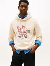 Buzo canguro Tommy Hilfiger de color blanco, con capucha ajustable por cordones y diseño gráfico deportivo en el pecho. Presenta un estilo urbano y relajado.