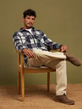 Camisa a cuadros azul marino y beige, de manga larga, con cuello clásico y dos bolsillos con solapa abotonada en el pecho.
