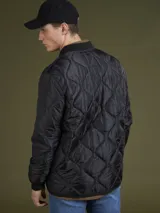 Campera acolchada verde militar con cuello mao, cierre frontal con botones a presión y bolsillos laterales.