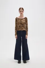 Remera de manga larga con cuello bote, confeccionada en tejido con estampado animal print tipo leopardo y borde negro en el escote.
