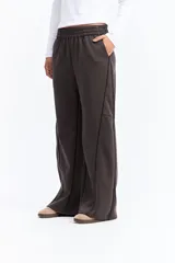 Pantalón de corte ancho y tiro alto, color gris oscuro, con cintura elástica y costuras frontales decorativas que recorren el largo de la pierna. Cuenta con bolsillos laterales funcionales.
