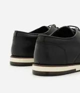 Zapato casual Viko para hombre de cuero marrón, tipo derby, con cordones del mismo tono, punta redondeada y suela plana en color blanco con detalles en negro y marrón oscuro.