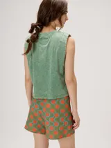 Short holgado de cintura alta con pretina integrada, cordón ajustable delantero y estampado geométrico en tonos rojos y beige.