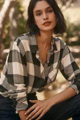 Camisa de manga larga con estampado tartán en tonos verde, gris y blanco, con cuello clásico, cierre frontal con botones, bolsillo en el pecho y corte regular.