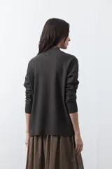 Polera de tejido de punto color gris oscuro, con cuello alto y diseño de rombos en relieve en el frente. Presenta un calce relajado con terminaciones en rib en cuello, puños y ruedo.