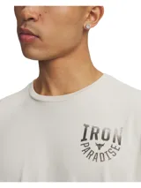 Remera de hombre color blanco hueso, con cuello redondo y manga corta. Presenta un estampado frontal en negro con el texto "IRON PARADISE" y el logo de Project Rock.