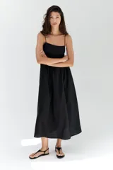 Vestido midi negro de mezcla de viscosa, con escote cuadrado y breteles finos dobles con detalle de moña. Canesú ajustado con parte posterior de punto smock y falda fruncida con volumen.