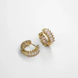 Par de aros tipo argolla dorados con cristales claros en la superficie interior y exterior.