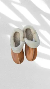 Pantuflas marrones con interior de corderito color crema.