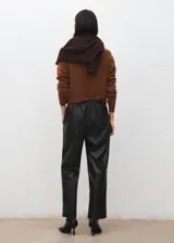 Pantalón de cuero sintético negro de corte recto, con cintura elástica ajustable mediante cordón y bolsillos laterales.