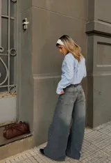 Pantalón de jean tiro bajo con corte baggy, diseño de costuras verticales frontales y botamangas anchas.