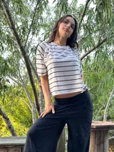 Blusa color beige de viscosa elastizada, con cuello bote y espalda cruzada. Estampado frontal con ilustración de una cara con corona de flores.