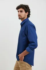 Camisa azul oscuro de manga larga con cuello abotonado y bolsillo en el pecho.