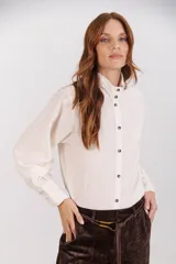 Camisa color crudo de cuello alto con botones y frunces en los puños y el cuello.