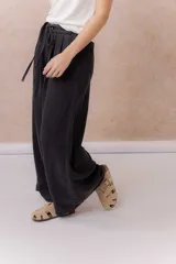 Jean de calce amplio y relajado, color azul, con pierna extra ancha y caída fluida. Diseño de tiro alto con pinzas delanteras y lazo regulable en la cintura. Cuenta con bolsillos laterales y traseros.