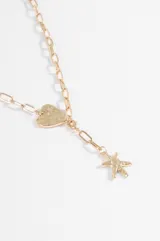 Collar de cadena de eslabones plateados con dije de corazón texturizado y dije colgante en forma de estrella de mar.
