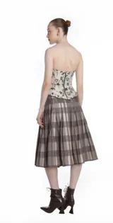 Corset estructurado de jacquard color blanco con estampado de rosas en tonos violetas y negros. Presenta escote corazón, cierre frontal con cremallera expuesta y volumen peplum en las caderas.