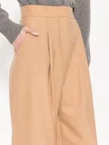 Pantalón de vestir color beige, de corte palazzo, con cintura alta y pinzas frontales.