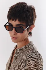 Lentes de sol con marco negro y patillas color carey.