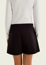 Short pollera azul marino con bolsillos delanteros simulados con solapa y cierre frontal oculto.